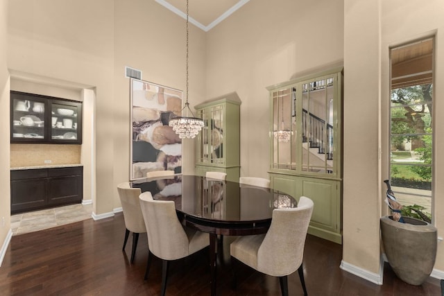 12417 Mediterra Pl, Austin, TX 78732 - dining space featuring ornamental molding, dark wood-style flooring, a high ceiling, stairway, and a chandelier