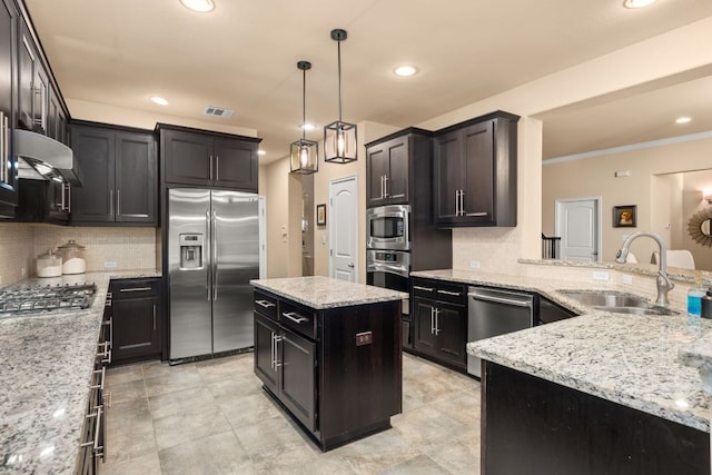12417 Mediterra Pl, Austin, TX 78732 - kitchen with stainless steel appliances, under cabinet range hood, decorative backsplash, recessed lighting, and light stone countertops