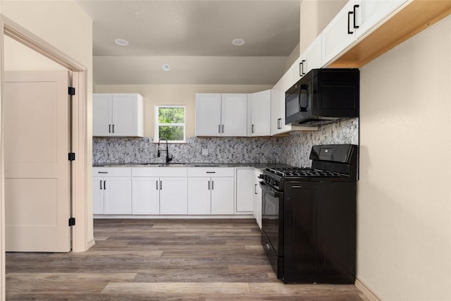417 S Blanco St, Lockhart, TX 78644 - kitchen featuring black appliances, white cabinets, backsplash, and wood finished floors