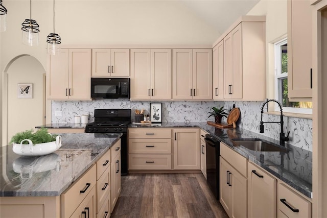 417 S Blanco St, Lockhart, TX 78644 - kitchen with black appliances, dark wood-type flooring, lofted ceiling, dark stone countertops, and decorative backsplash