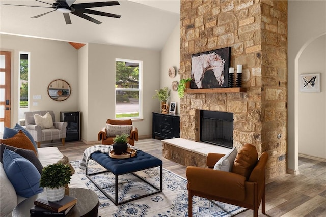 417 S Blanco St, Lockhart, TX 78644 - living room featuring a fireplace, wood finished floors, ceiling fan, arched walkways, and vaulted ceiling