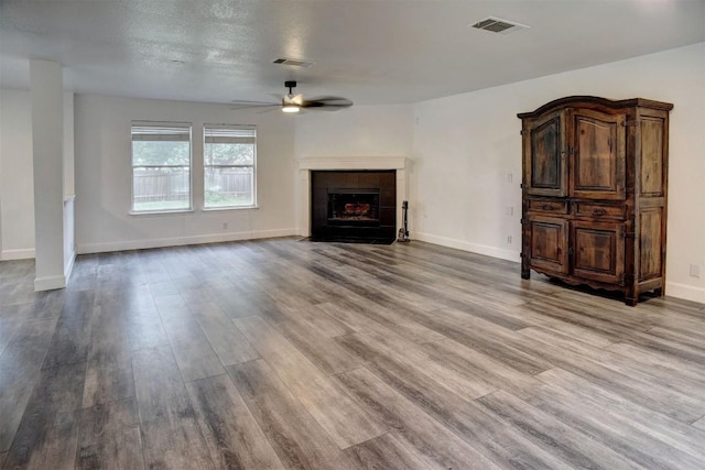 742 Annika Way, Bastrop, TX 78602 - unfurnished living room featuring a ceiling fan, wood finished floors, and a tiled fireplace