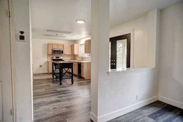 742 Annika Way, Bastrop, TX 78602 - kitchen with light brown cabinetry, stainless steel microwave, dishwashing machine, dark wood-style flooring, and light countertops