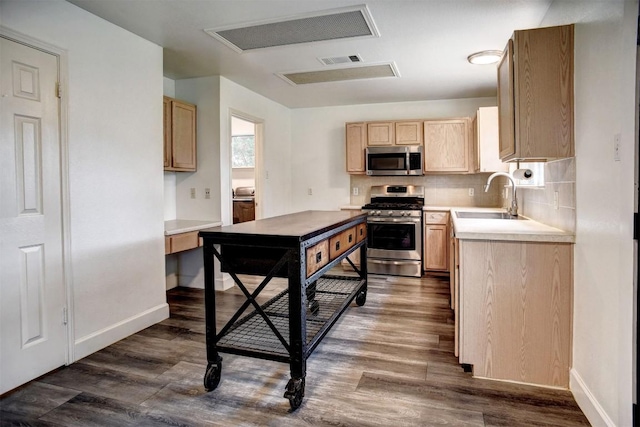 742 Annika Way, Bastrop, TX 78602 - kitchen featuring appliances with stainless steel finishes, dark wood-style floors, light brown cabinets, light countertops, and tasteful backsplash