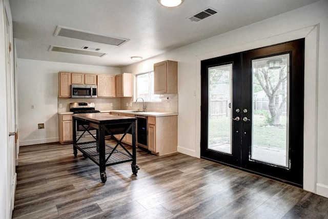 742 Annika Way, Bastrop, TX 78602 - kitchen with appliances with stainless steel finishes, light brown cabinets, french doors, wood finished floors, and light countertops