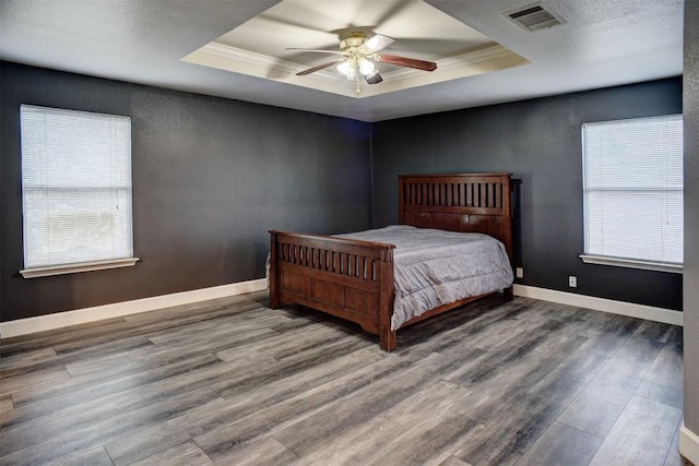 742 Annika Way, Bastrop, TX 78602 - bedroom featuring a raised ceiling, wood finished floors, multiple windows, crown molding, and ceiling fan