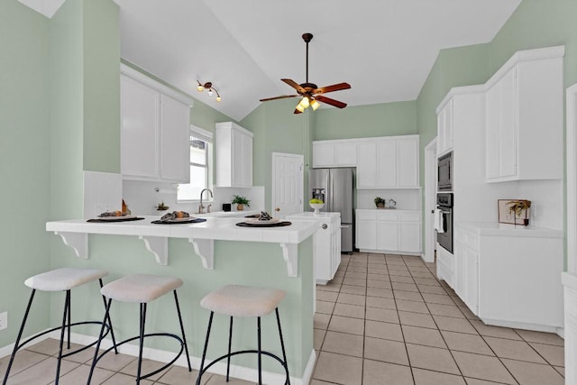 207 Golf Crest Ln, Lakeway, TX 78734 - kitchen featuring stainless steel appliances, a peninsula, light tile patterned floors, white cabinetry, and ceiling fan