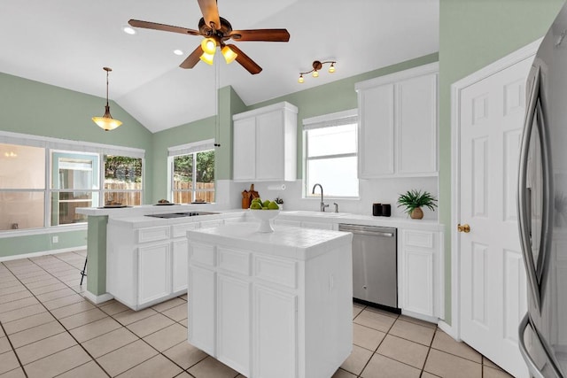 207 Golf Crest Ln, Lakeway, TX 78734 - kitchen with appliances with stainless steel finishes, light tile patterned floors, a center island, lofted ceiling, and white cabinets