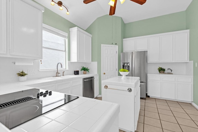 207 Golf Crest Ln, Lakeway, TX 78734 - kitchen with appliances with stainless steel finishes, ceiling fan, tile counters, backsplash, and a kitchen island