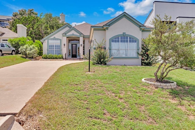 207 Golf Crest Ln, Lakeway, TX 78734 - view of front of house with stucco siding, a front lawn, a chimney, and driveway