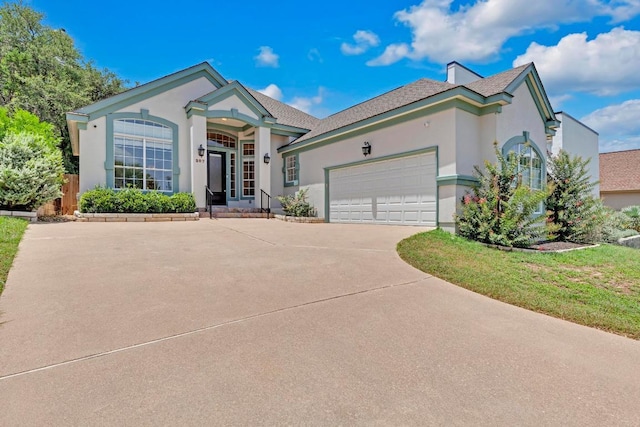 207 Golf Crest Ln, Lakeway, TX 78734 - view of front facade featuring stucco siding, concrete driveway, an attached garage, and roof with shingles
