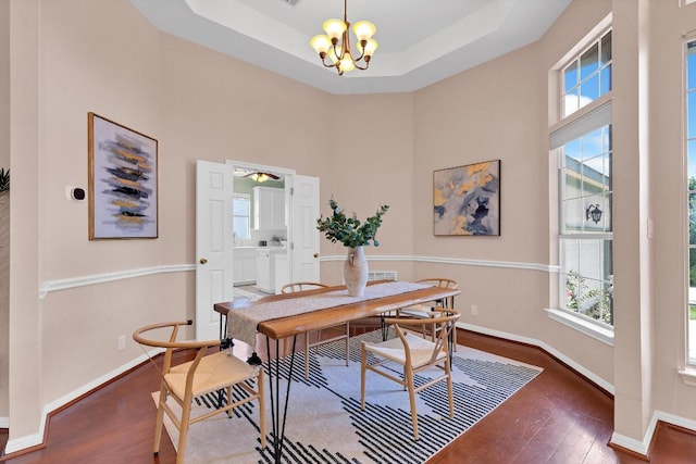 207 Golf Crest Ln, Lakeway, TX 78734 - dining room with wood-type flooring, a towering ceiling, a chandelier, and a tray ceiling