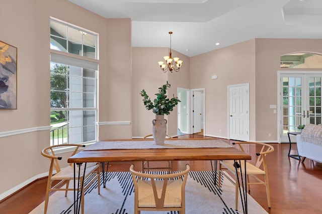 207 Golf Crest Ln, Lakeway, TX 78734 - dining space featuring plenty of natural light, wood finished floors, a chandelier, french doors, and a towering ceiling