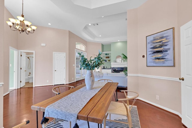 207 Golf Crest Ln, Lakeway, TX 78734 - dining area with a chandelier, recessed lighting, a raised ceiling, wood finished floors, and a fireplace