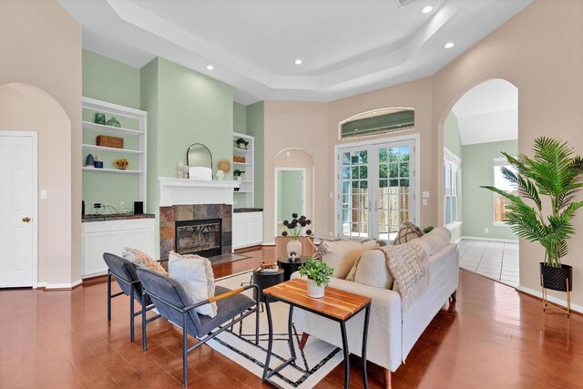 207 Golf Crest Ln, Lakeway, TX 78734 - living room with recessed lighting, arched walkways, a towering ceiling, a tiled fireplace, and a tray ceiling