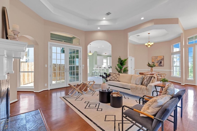 207 Golf Crest Ln, Lakeway, TX 78734 - living area with a raised ceiling, arched walkways, wood finished floors, recessed lighting, and a chandelier