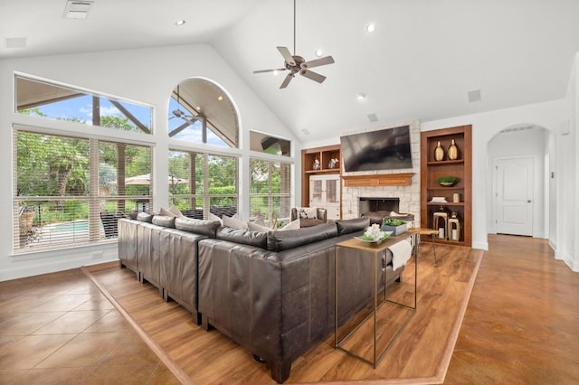 9 Heatherbloom Ln, The Hills, TX 78738 - living area with built in features, ceiling fan, arched walkways, high vaulted ceiling, and a fireplace