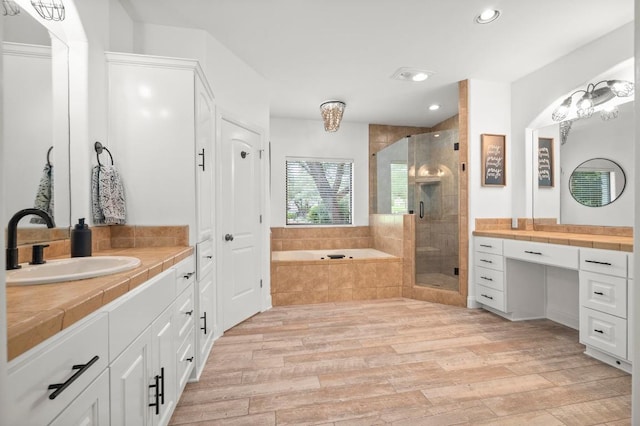 9 Heatherbloom Ln, The Hills, TX 78738 - full bathroom featuring a stall shower, wood finished floors, a bath, vanity, and recessed lighting