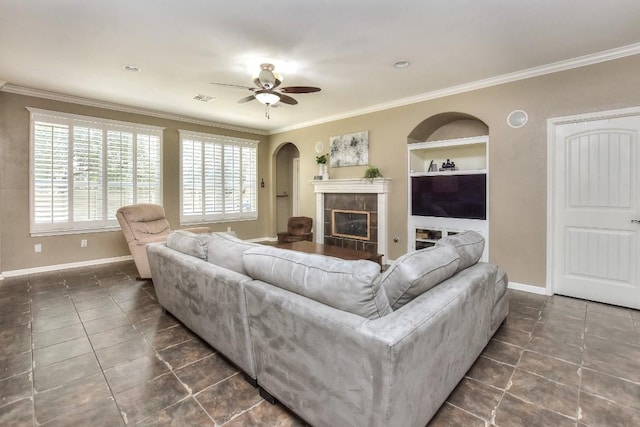 1108 Ritter Dr, Cedar Park, TX 78613 - living room with dark tile patterned floors, ceiling fan, ornamental molding, a fireplace, and arched walkways