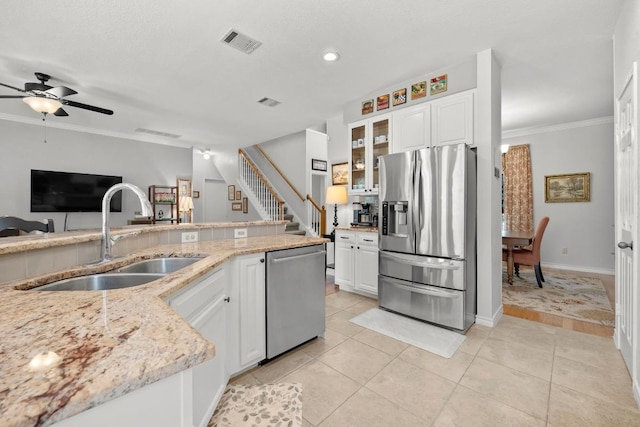 7900 Monona Ave, Austin, TX 78717 - kitchen with appliances with stainless steel finishes, a ceiling fan, light stone countertops, white cabinets, and crown molding
