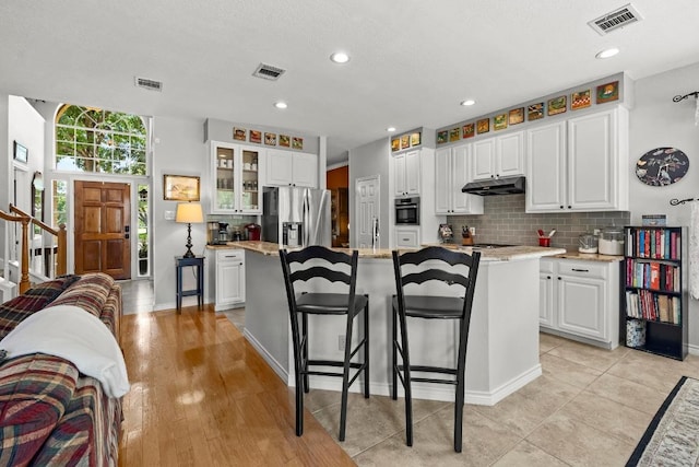 7900 Monona Ave, Austin, TX 78717 - kitchen featuring stainless steel appliances, tasteful backsplash, under cabinet range hood, a kitchen island, and recessed lighting