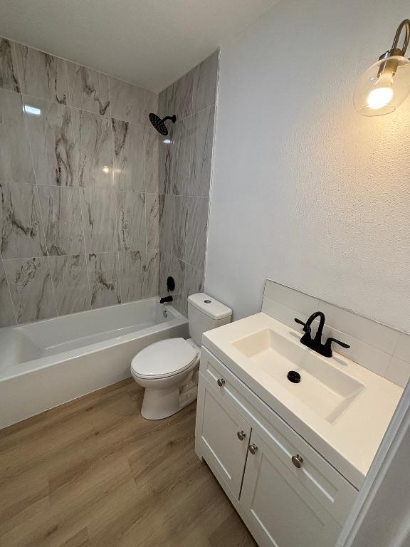 4608 E Village Ct, Austin, TX 78744 - full bathroom featuring vanity, shower / bath combination, and wood finished floors