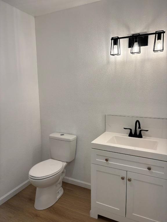 4608 E Village Ct, Austin, TX 78744 - half bathroom featuring vanity and wood finished floors