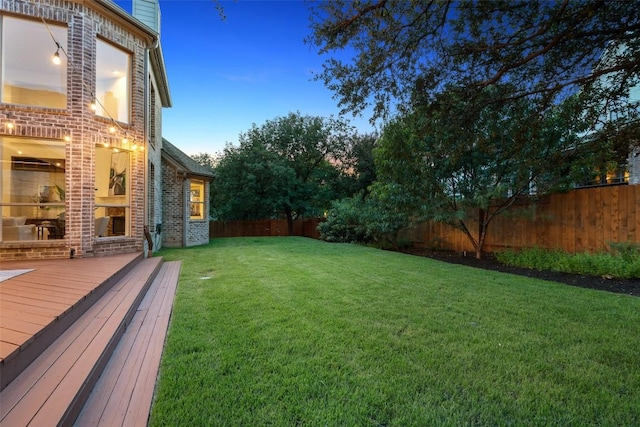 3803 Katie Ln, Cedar Park, TX 78613 - yard at dusk featuring a fenced backyard and a wooden deck