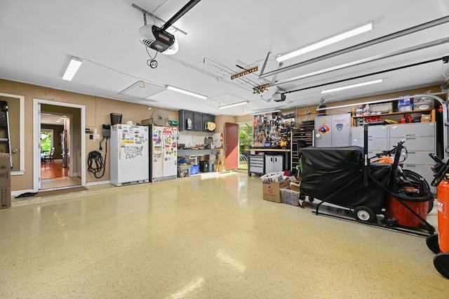 2400 Muirfield Cir, Austin, TX 78747 - garage featuring freestanding refrigerator, a garage door opener, and a workshop area