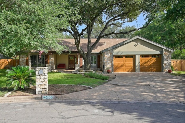 2400 Muirfield Cir, Austin, TX 78747 - view of front of home with stone siding, an attached garage, and concrete driveway