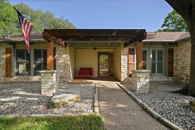 2400 Muirfield Cir, Austin, TX 78747 - doorway to property with stone siding, a pergola, and a shingled roof