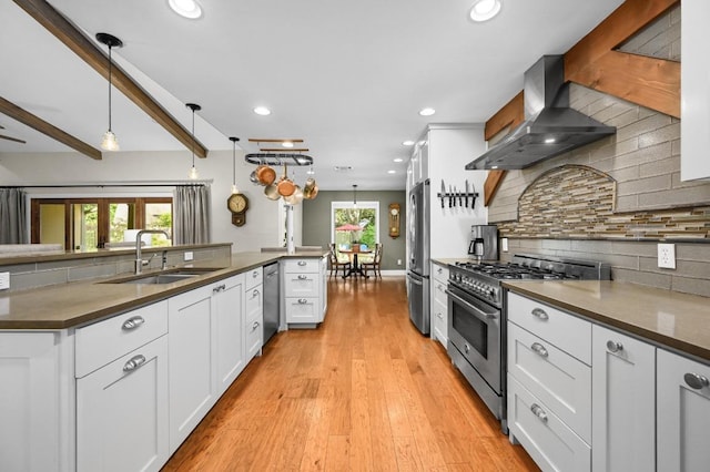 2400 Muirfield Cir, Austin, TX 78747 - kitchen featuring wall chimney exhaust hood, stainless steel appliances, dark countertops, recessed lighting, and white cabinets