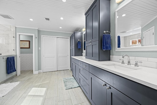 2400 Muirfield Cir, Austin, TX 78747 - full bathroom with double vanity, recessed lighting, ornamental molding, and a wainscoted wall