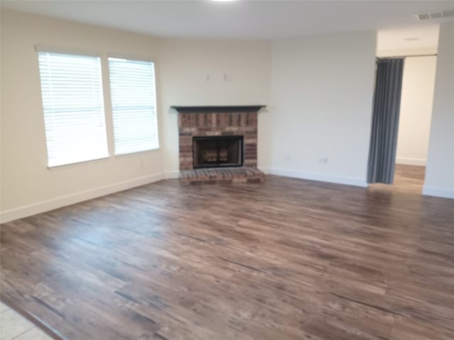 11540 Arbroath Ln, Austin, TX 78754 - unfurnished living room with wood finished floors and a brick fireplace