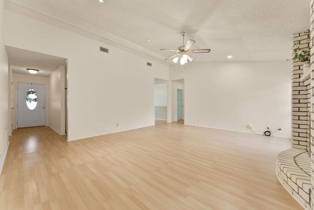 2014 Stagecoach Trl, Temple, TX 76502 - unfurnished living room with a ceiling fan, light wood finished floors, and a textured ceiling