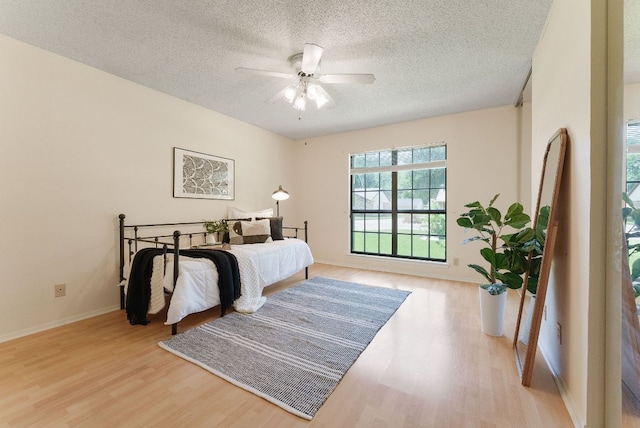 2014 Stagecoach Trl, Temple, TX 76502 - bedroom with light wood finished floors, a textured ceiling, and ceiling fan