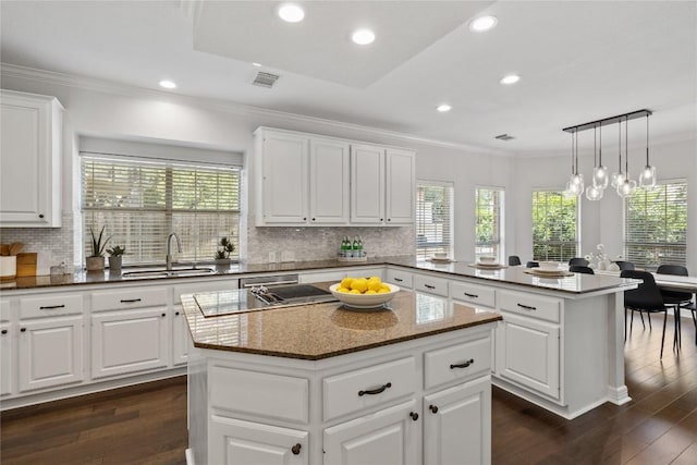 11235 Tracton Ln, Austin, TX 78739 - kitchen with a center island, a peninsula, recessed lighting, tasteful backsplash, and dark wood-style flooring