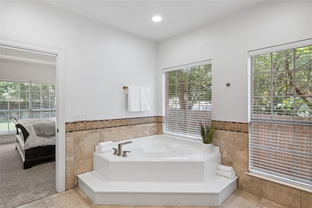 11235 Tracton Ln, Austin, TX 78739 - bathroom with tile walls, ensuite bathroom, tile patterned flooring, a garden tub, and a wainscoted wall