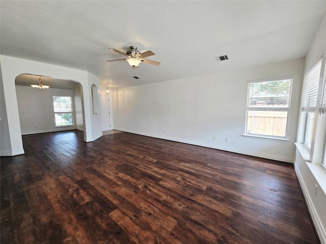 707 Johnny Bench, Round Rock, TX 78665 - empty room featuring arched walkways, dark wood-type flooring, ceiling fan, and a chandelier