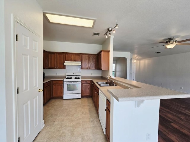 707 Johnny Bench, Round Rock, TX 78665 - kitchen featuring white appliances, under cabinet range hood, a peninsula, light countertops, and open floor plan