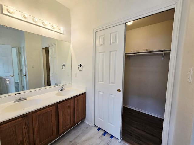 707 Johnny Bench, Round Rock, TX 78665 - bathroom with double vanity, a walk in closet, and wood finished floors