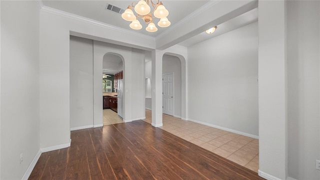 403 Warm Breeze Cv, Austin, TX 78717 - spare room with arched walkways, a chandelier, crown molding, and wood finished floors