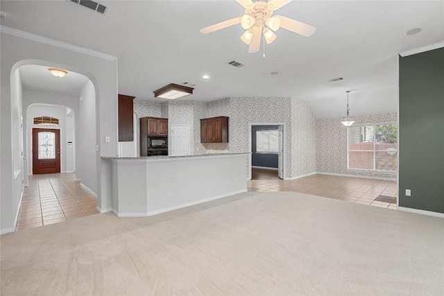403 Warm Breeze Cv, Austin, TX 78717 - unfurnished living room with light carpet, light tile patterned floors, a ceiling fan, arched walkways, and crown molding