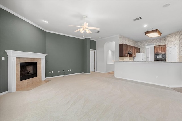 403 Warm Breeze Cv, Austin, TX 78717 - unfurnished living room with arched walkways, ceiling fan, a tile fireplace, crown molding, and light carpet