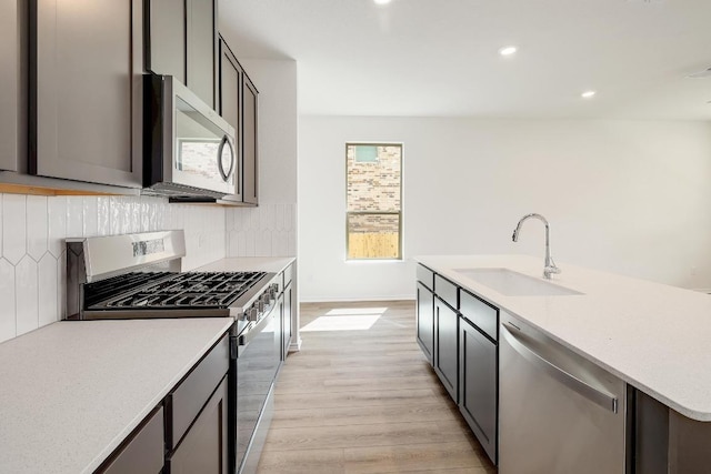 4935 Mozzafiato Ln, Round Rock, TX 78665 - kitchen with stainless steel appliances, light wood-type flooring, backsplash, light countertops, and recessed lighting
