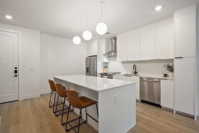 1701 Simond Ave Unit 305, Austin, TX 78723 - kitchen with stainless steel appliances, wall chimney exhaust hood, a kitchen breakfast bar, a kitchen island, and decorative backsplash