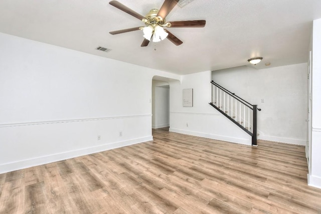 1401 Balsam Way, Round Rock, TX 78665 - unfurnished living room with ceiling fan, stairway, light wood-style floors, and arched walkways