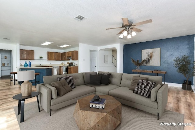 1401 Balsam Way, Round Rock, TX 78665 - living area with light wood finished floors, ceiling fan, and arched walkways