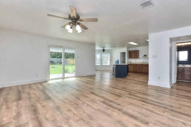 1401 Balsam Way, Round Rock, TX 78665 - unfurnished living room featuring ceiling fan, plenty of natural light, and light wood finished floors