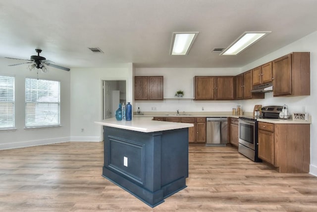 1401 Balsam Way, Round Rock, TX 78665 - kitchen featuring stainless steel appliances, under cabinet range hood, light wood finished floors, and light countertops